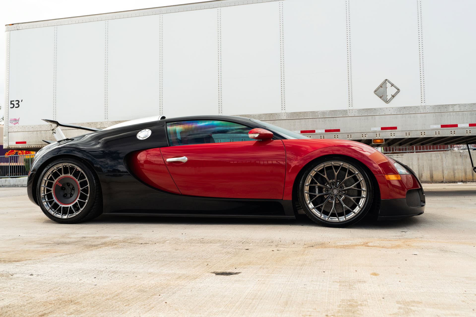 Bugatti Chiron with custom wheels and black-red paint, showcasing luxury and high-performance automo.